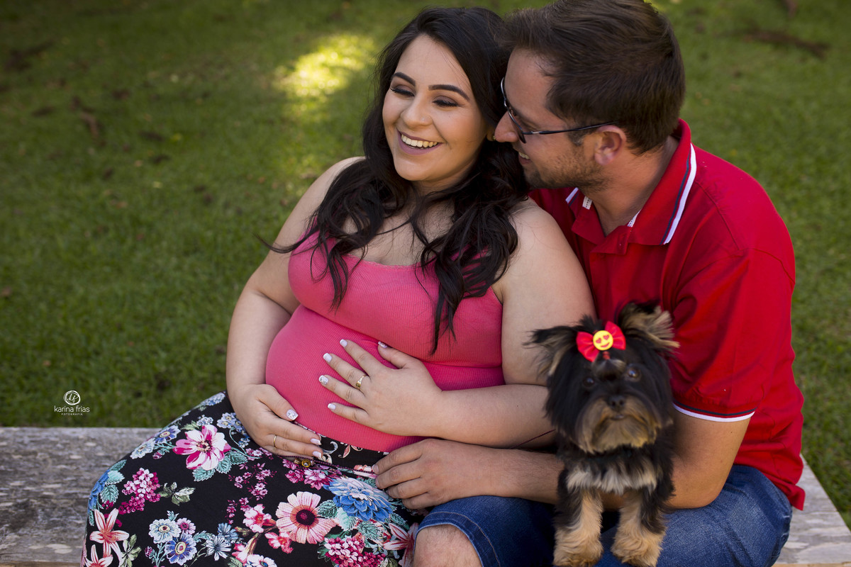 os pais sorriem no ensaio externo de gestante 