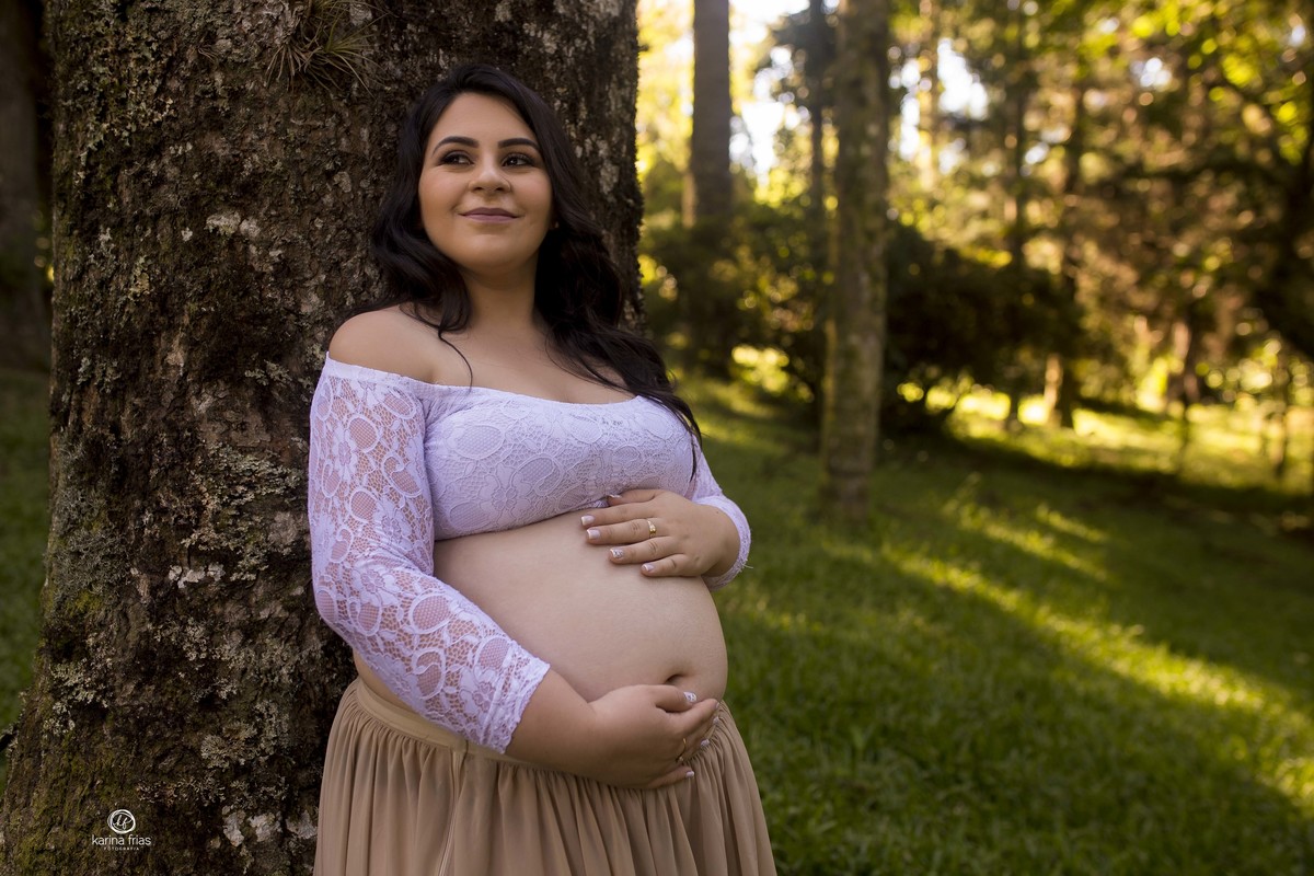 a gestante segura a barriga para as fotos do seu book