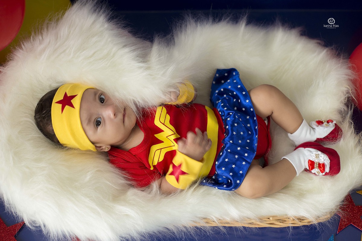 no ensaio infantil a menina esta vestida de mulher maravilha