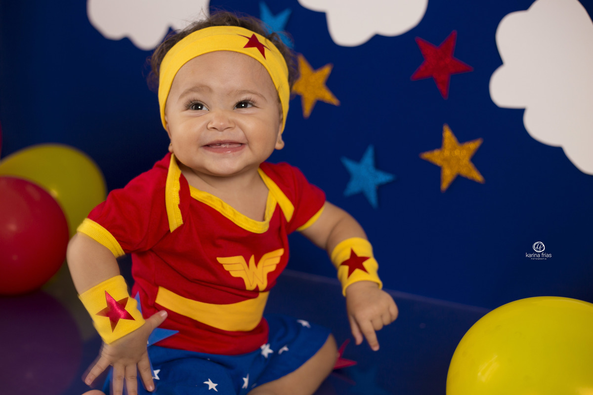 a bebe se diverte nas suas fotos mensais