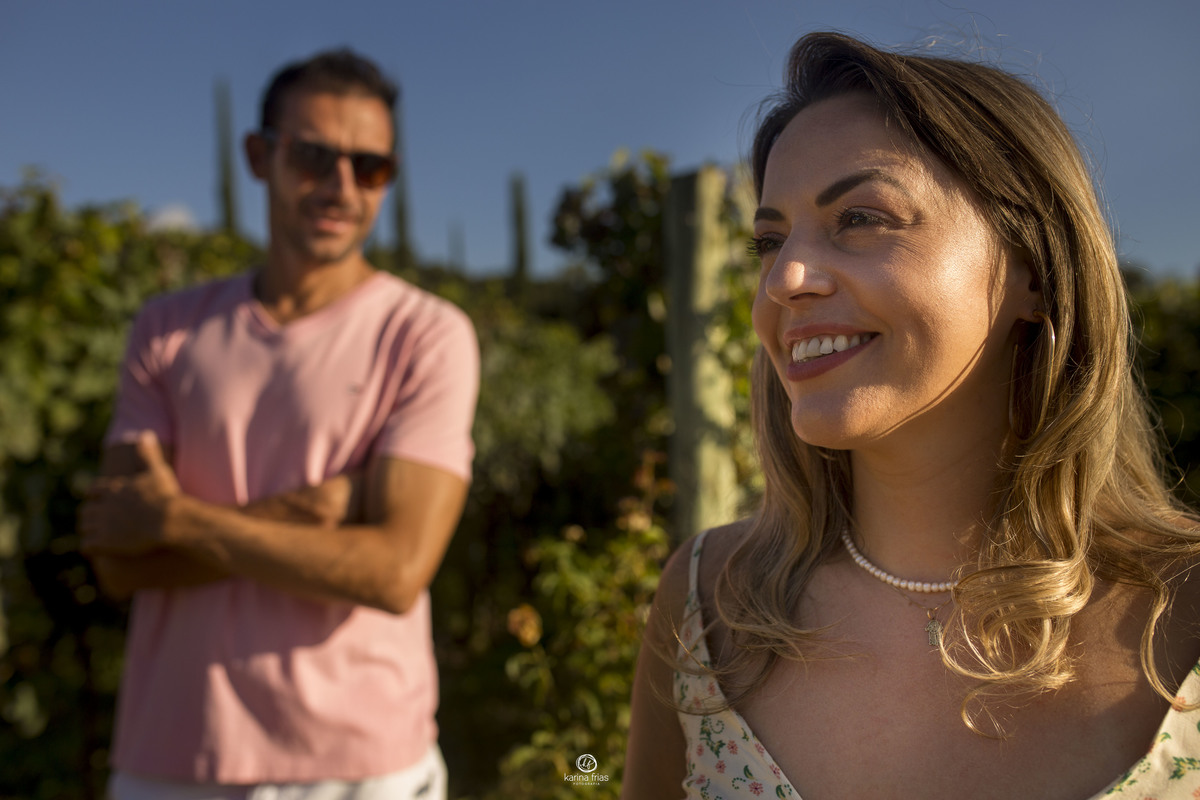 o homem esta desfocado ao fundo olhando para a mulher