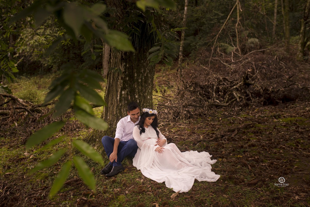 os pais sentam abaixo da arvore para as fotos externas