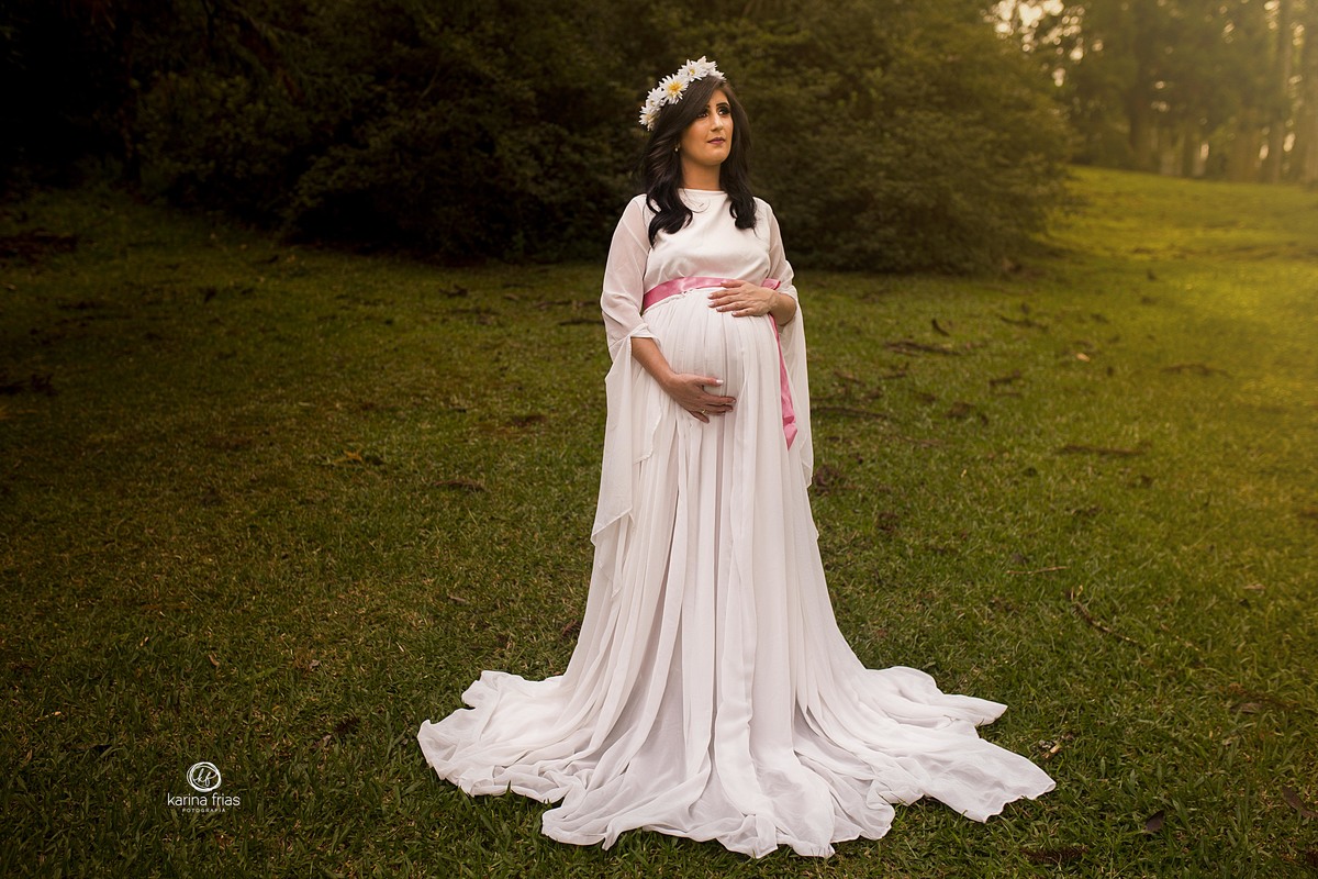 a gestante contempla a paisagem no ensaio