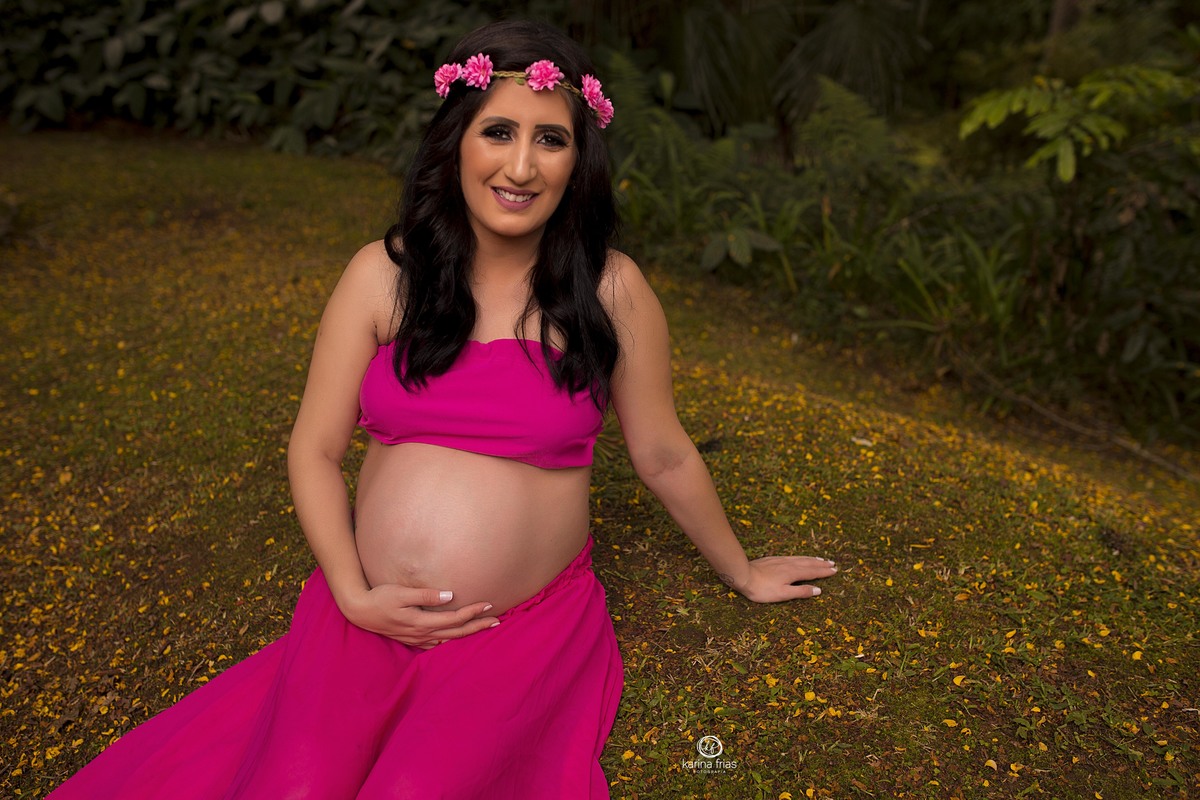 a gestante esta sentada para as fotos do  book