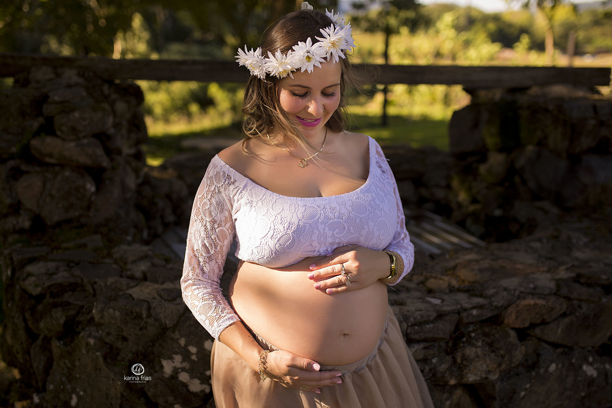 a gestante olha para a barriga no ensaio externo