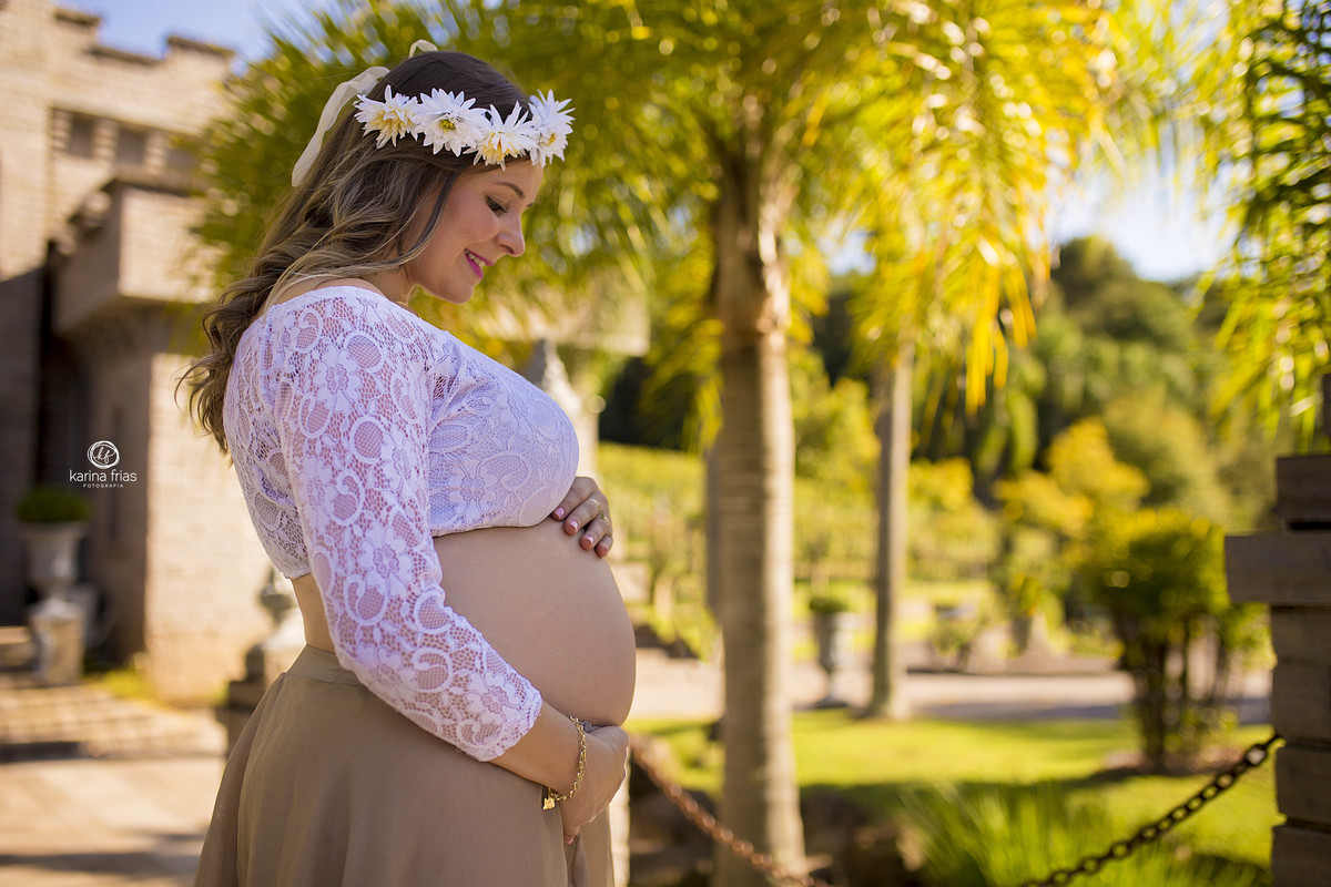 a mamae olha para a barriga na sessão de fotos