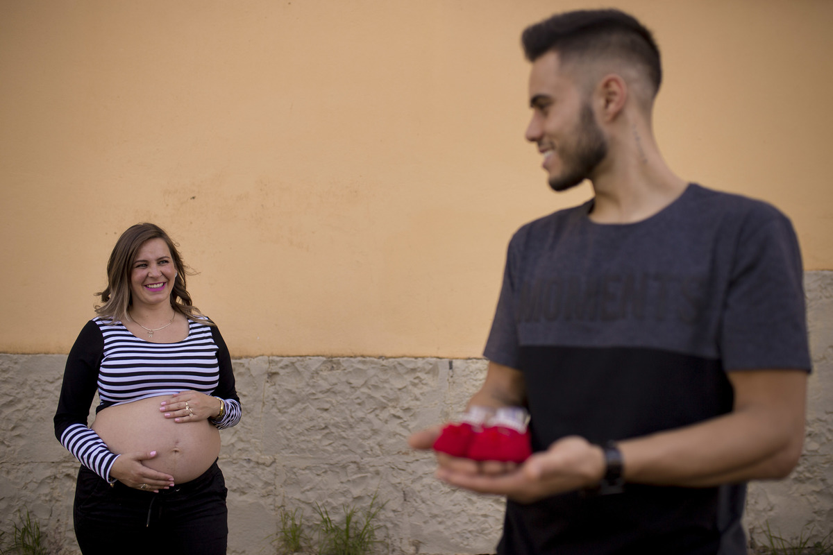 os pais se olham nas fotos externas de gestante