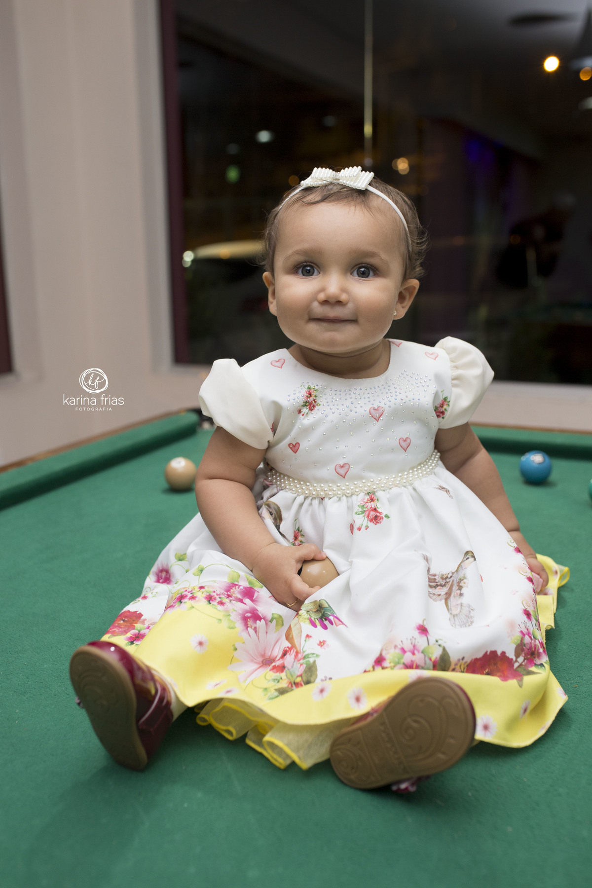a manina esta sentada na mesa de sinuca da casa de festas