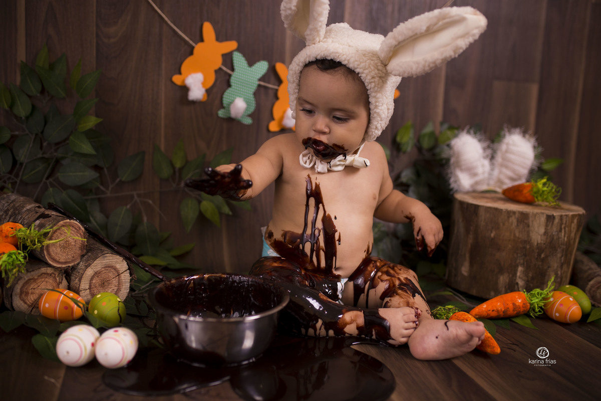 o bebe brinca com o chocolate no ensaio de estudio