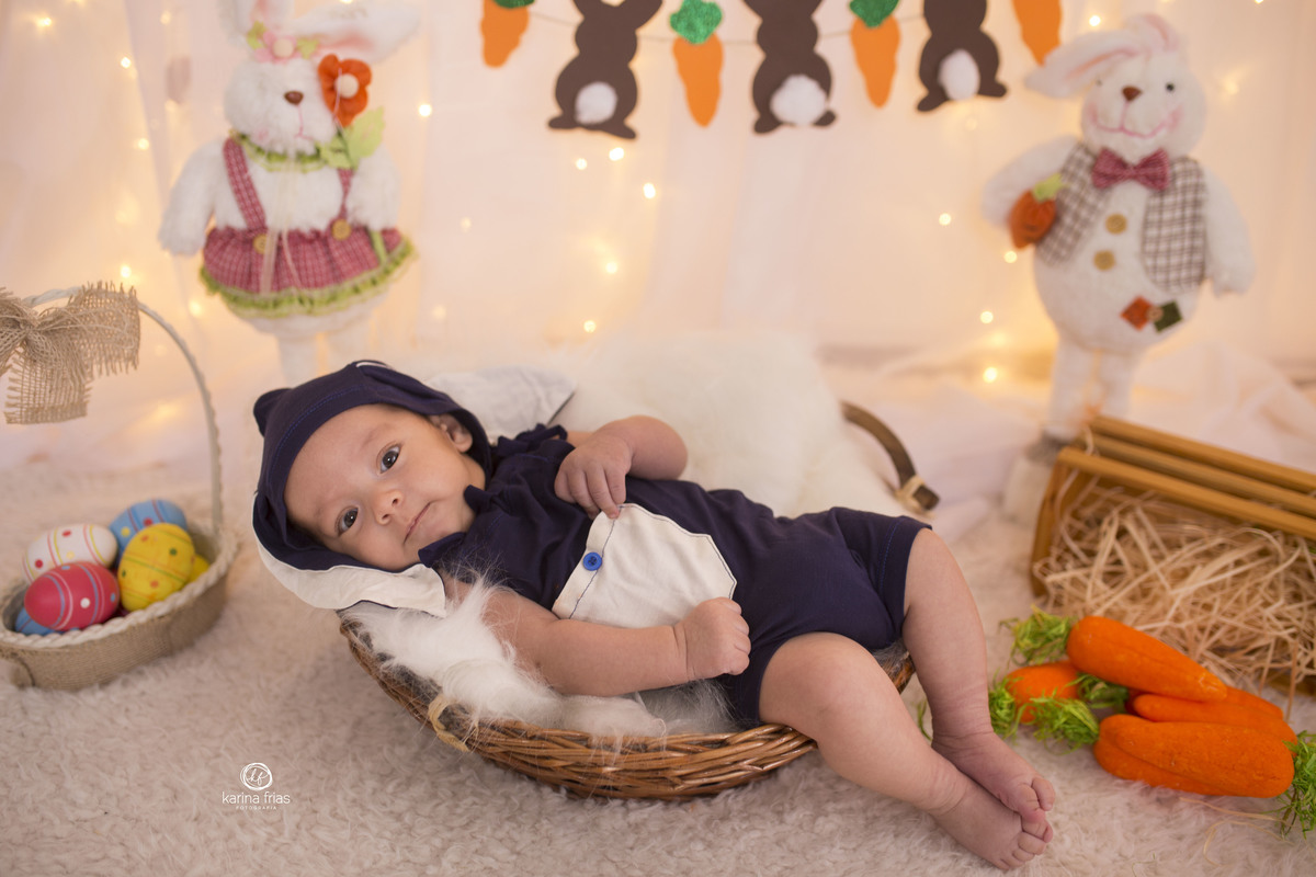 a criança esta deitada no cenario de pascoa