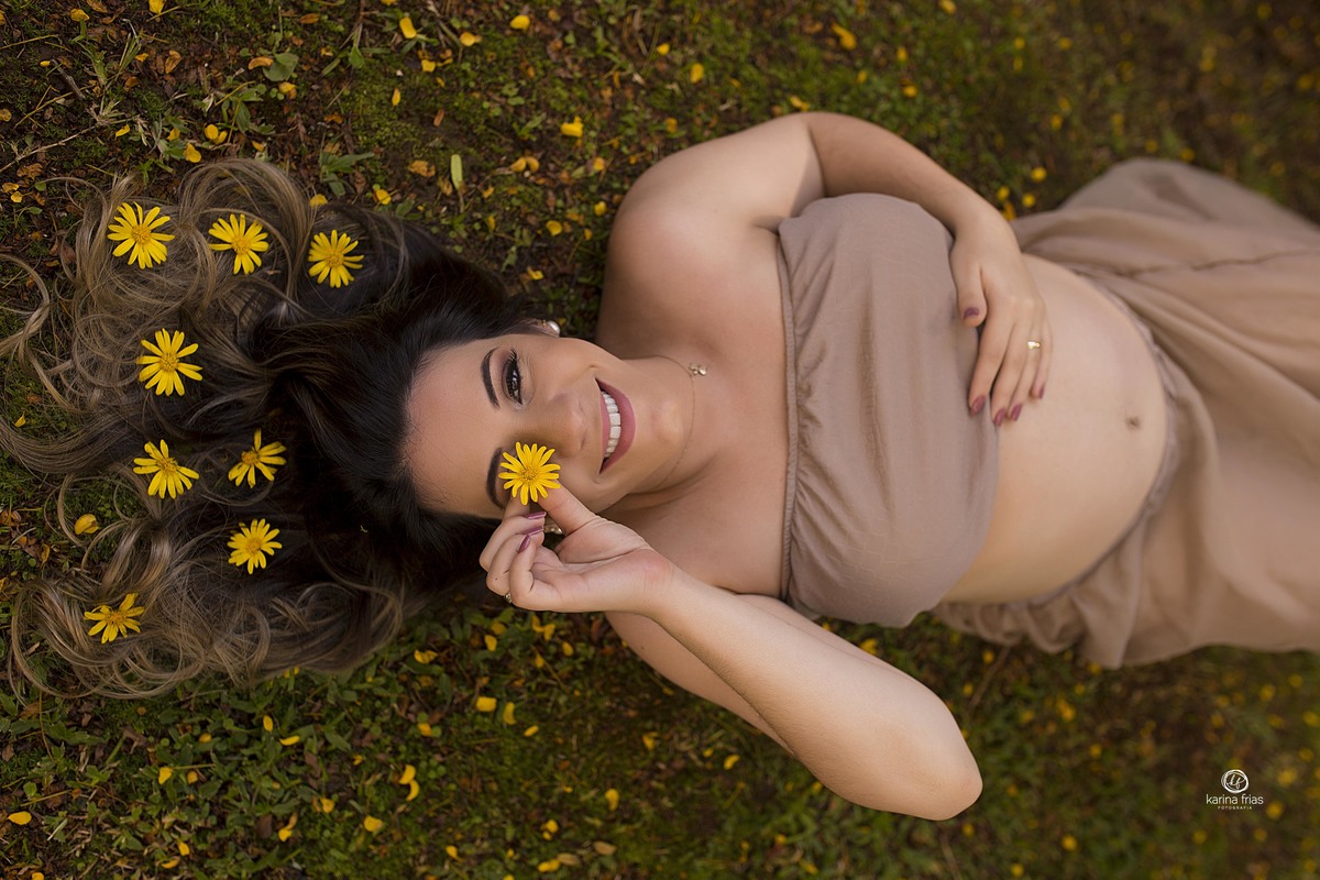 a gestante usa flores no cabelo para as fotos externas