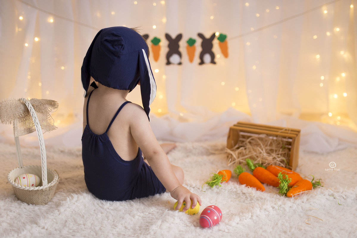 no ensaio de pascoa infantil a criança observa o cenario