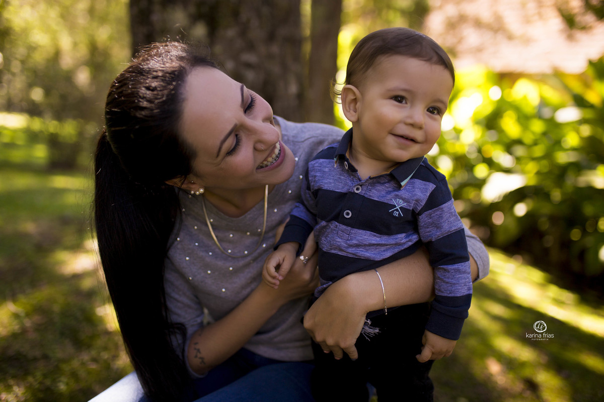 a mae sorri com o bebe no ensaio externo
