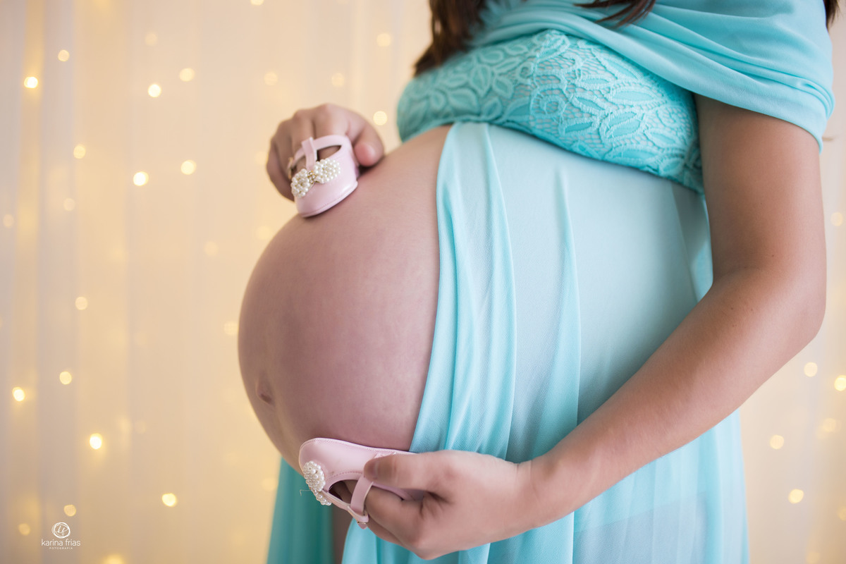 a mae apoia os sapatinhos na barriga de gestante