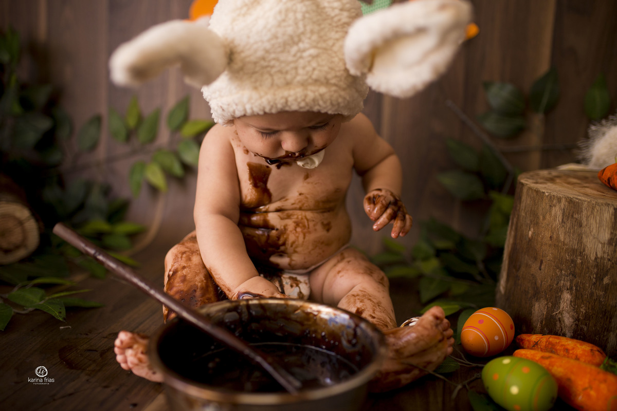 o bebe brinca com o chocolate no ensaio infantil