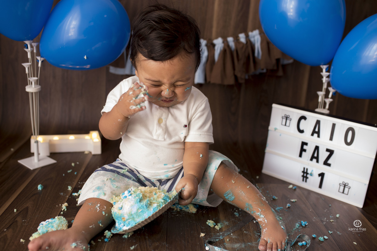 a criança tenta limpar as mãos do bolo