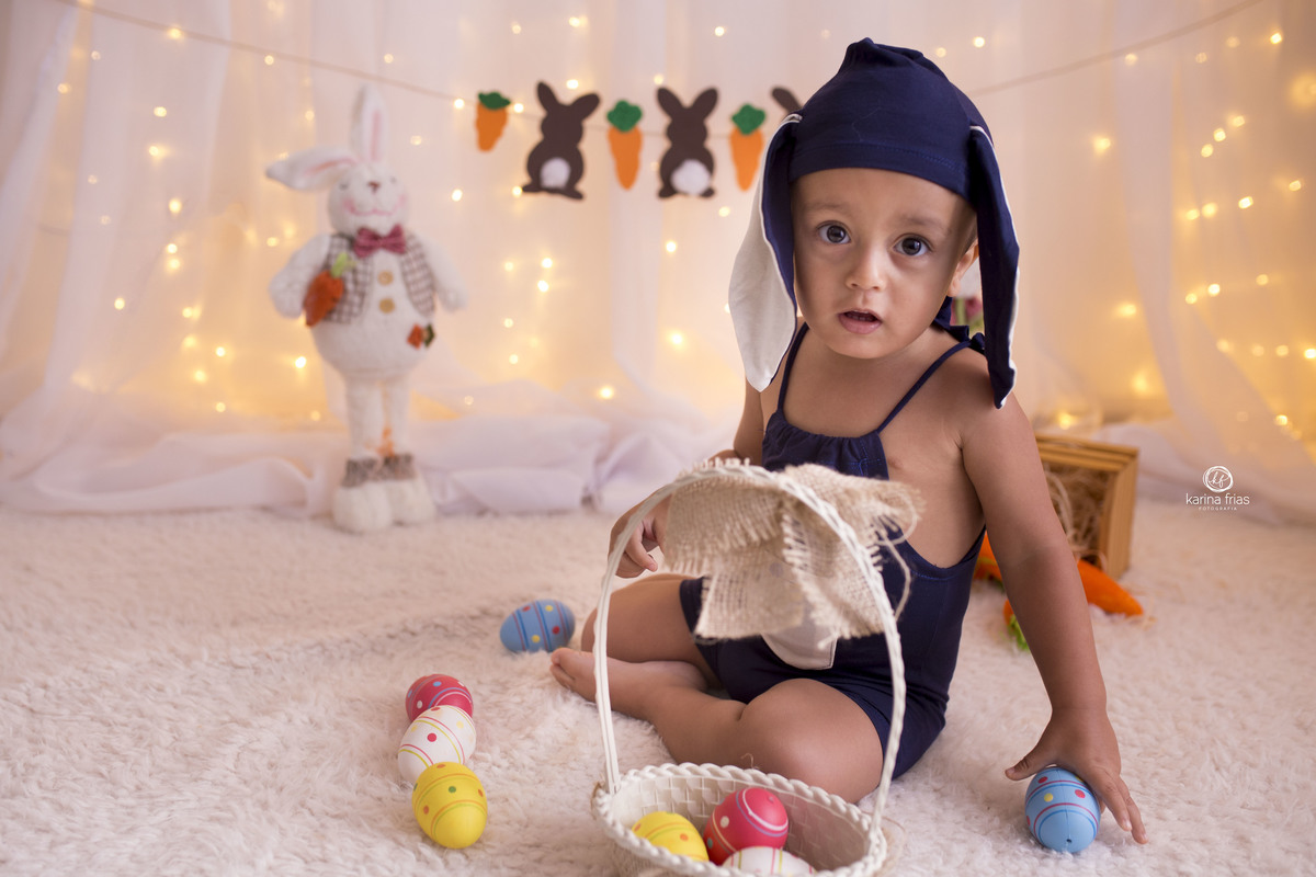 NO ENSAIO DE PASCOA A CRIANÇA BRINCA COM OS OVOS