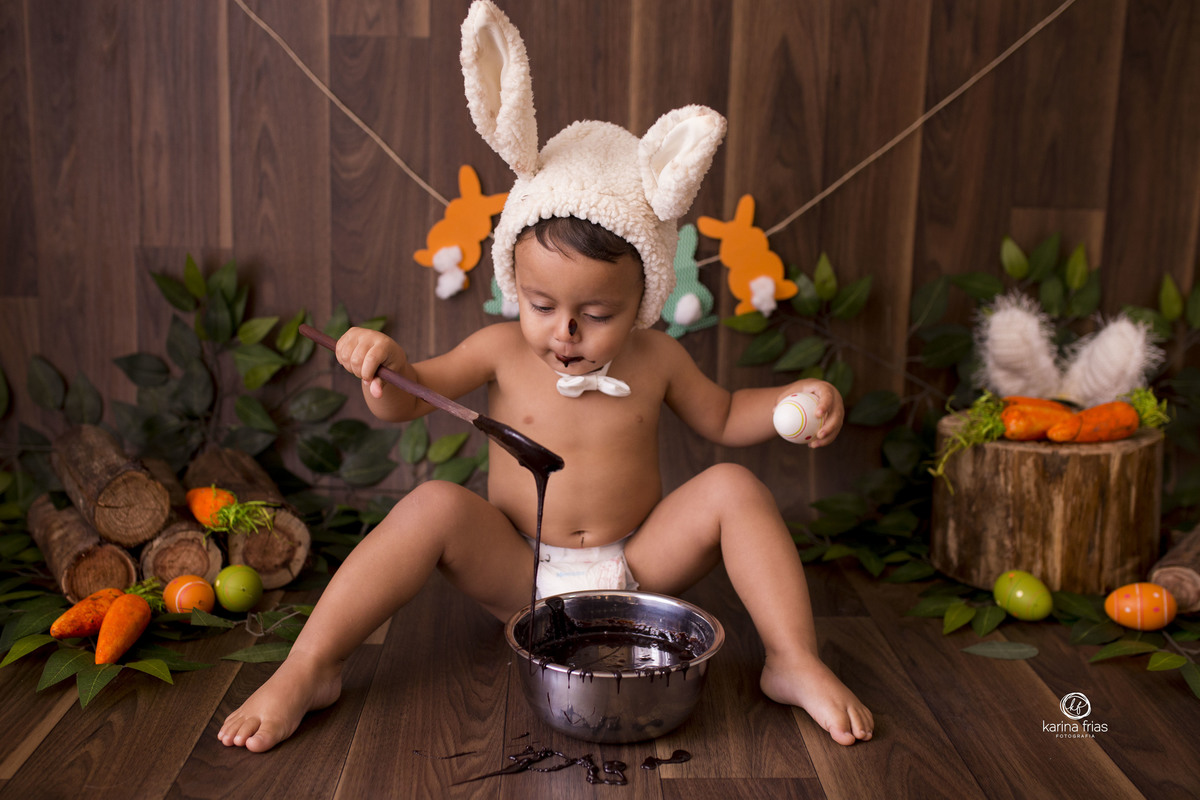 O BEBE BRINCA COM O CHOCOLATE NO CENARIO DE PASCOA