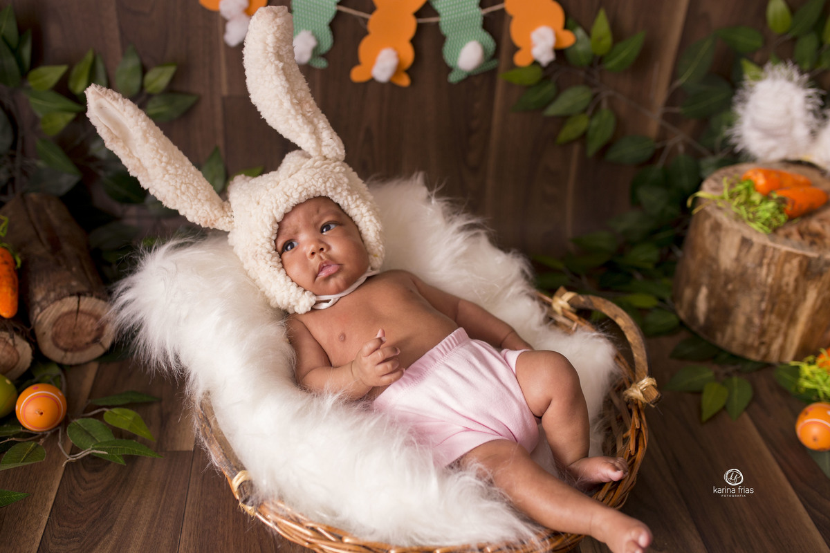 a bebe esta deitada na cesta no cenario de pascoa