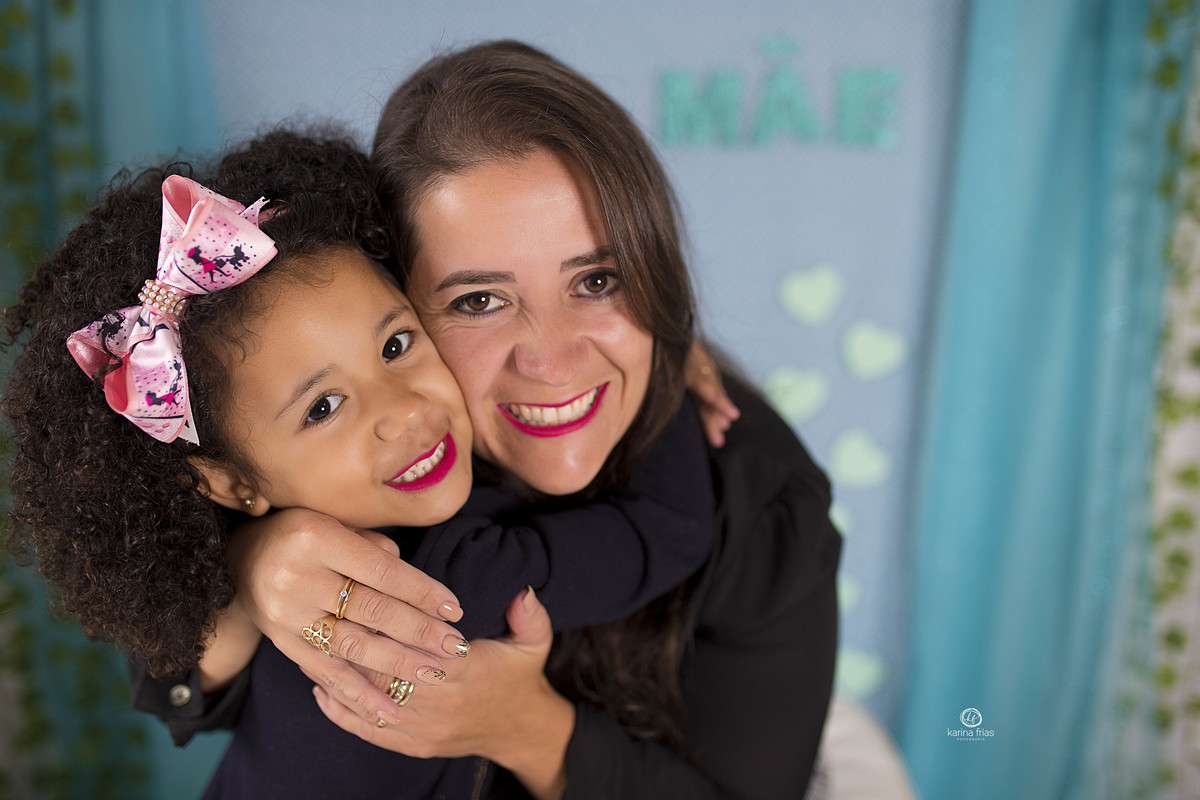 a mae abraça a filha durante o ensaio de dia das maes 