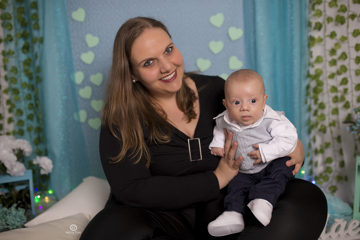 o bebe esta no colo da mae para as fotos de dia das mães
