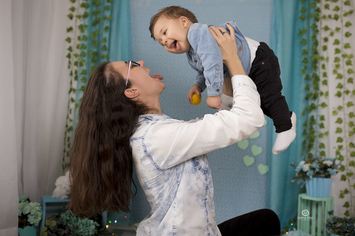 a mae brinca com o filho enquanto a fotografa de familia registra o momento