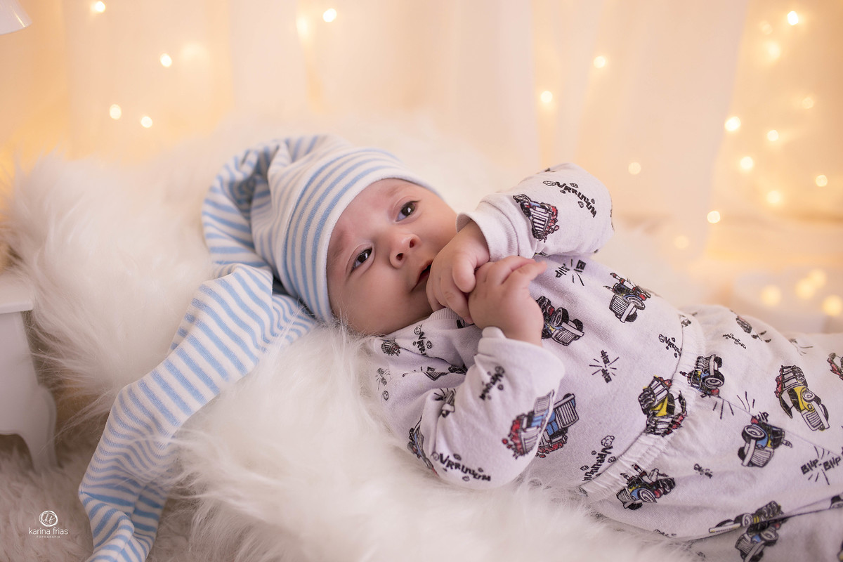 o bebe esta deitado no cenario de quarto