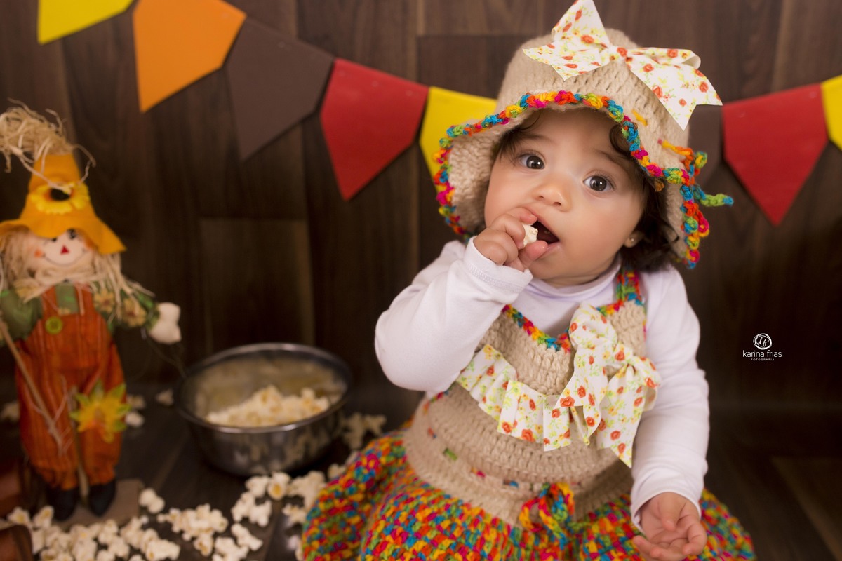 no ensaio de festa junina infantil a bebe olha para a fotografa de familia de caxias do sul - rs