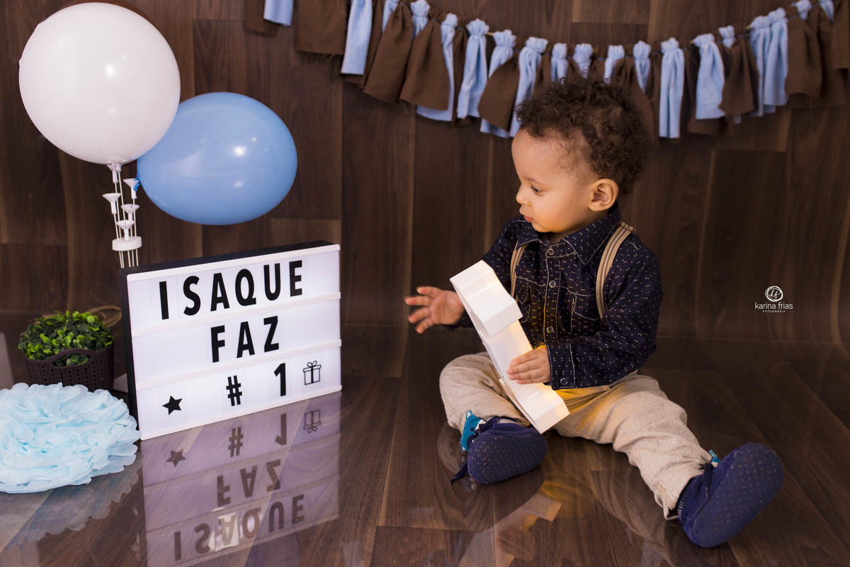 o bebe olha para a placa do seu aniversario