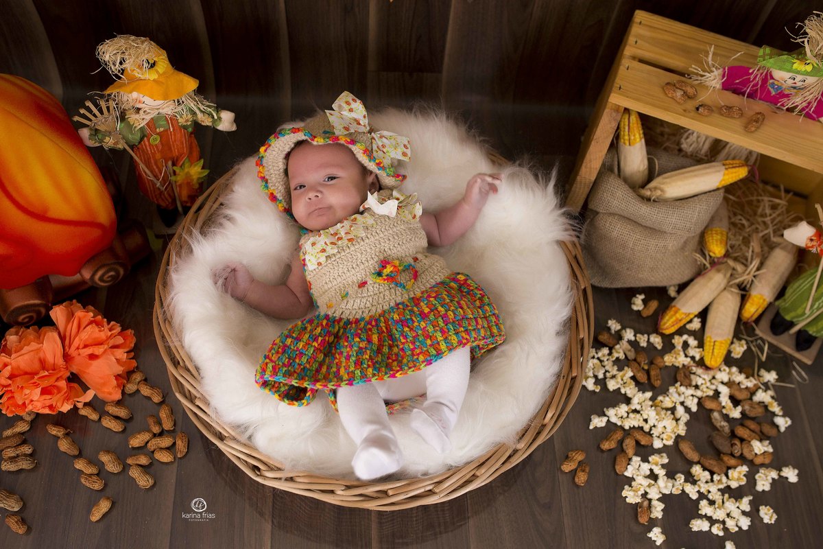 a bebe esta deitada no cenario de festa junina