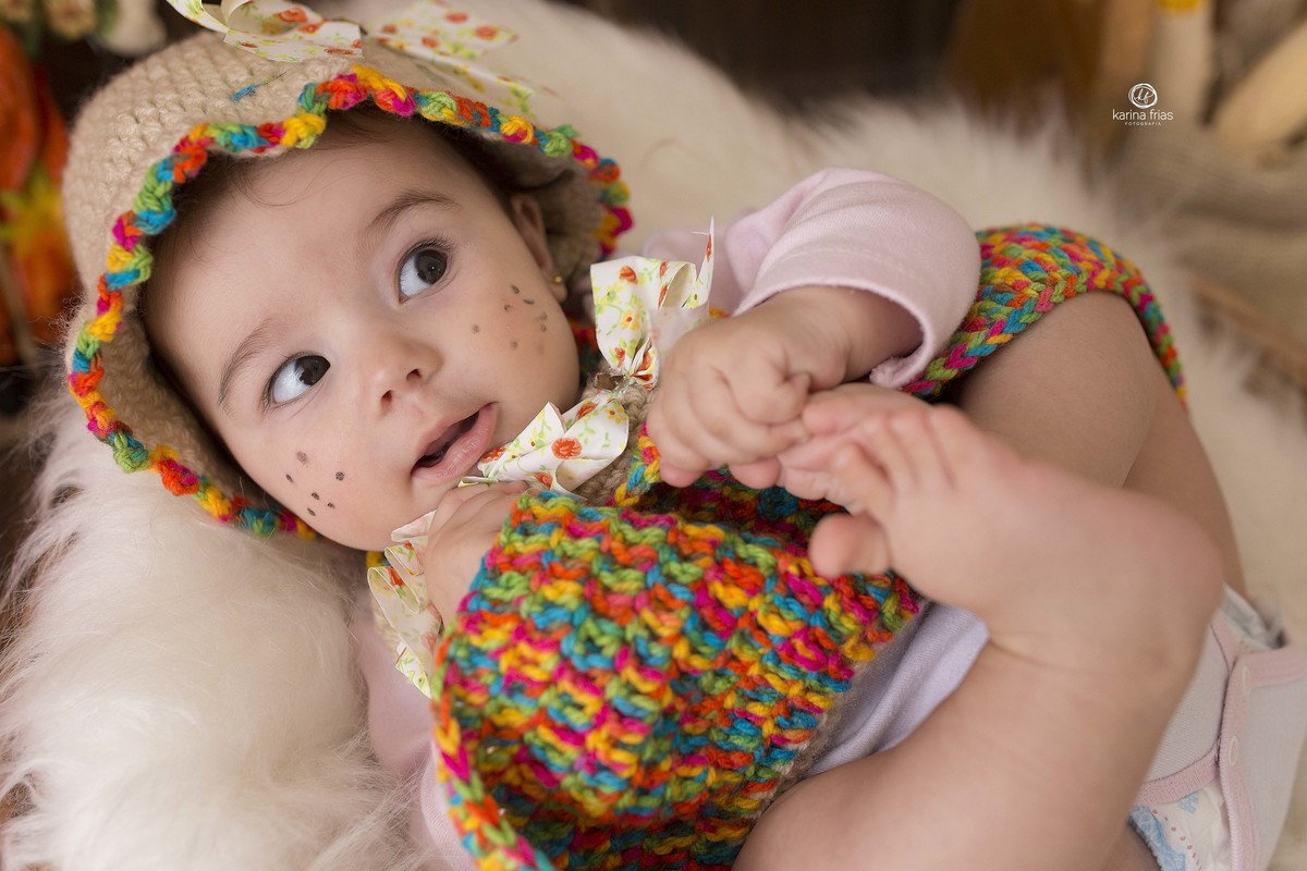 a bebe esta deitada no cenario de festa junina
