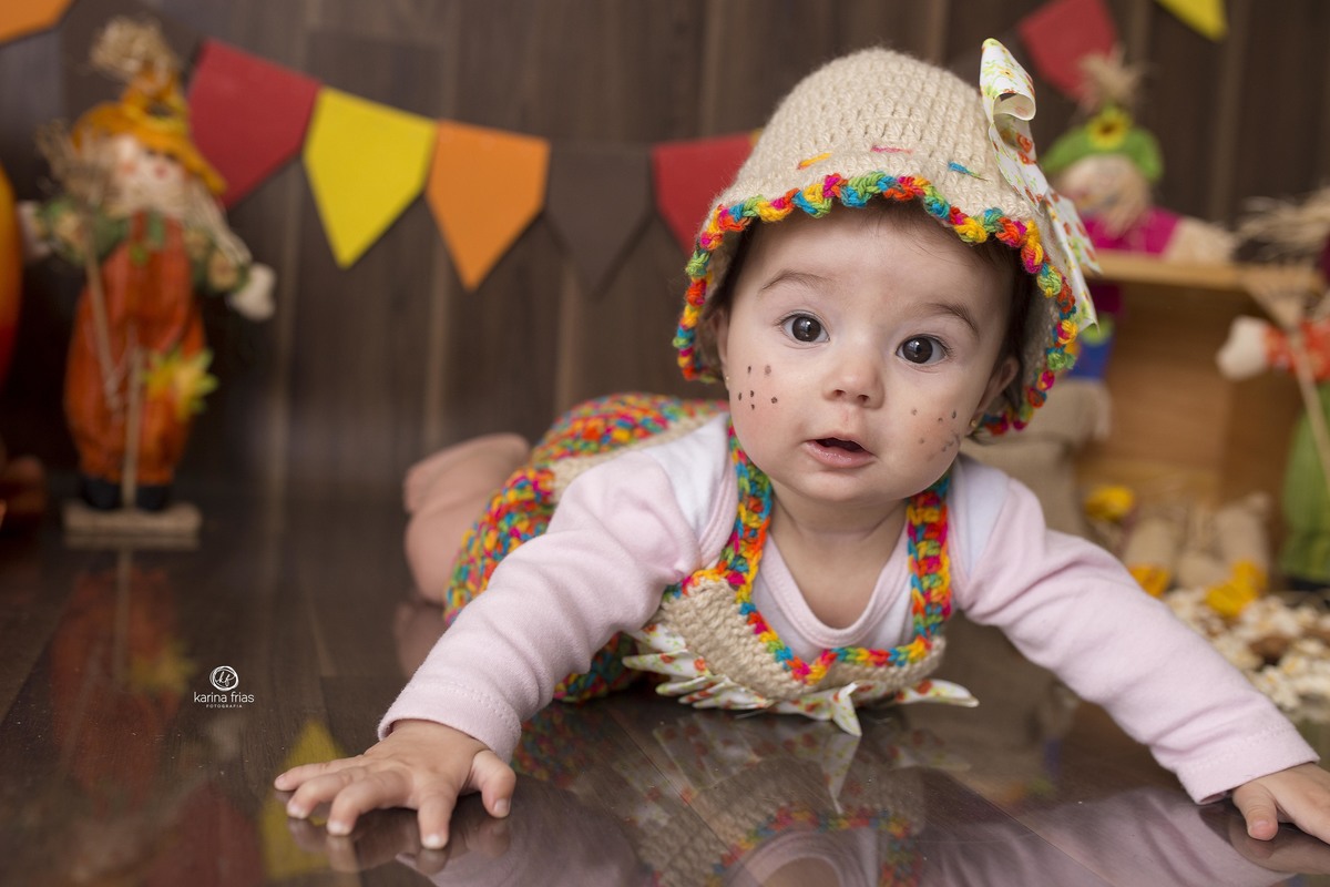 a menina fica de bruços para a sessão de fotos juninas