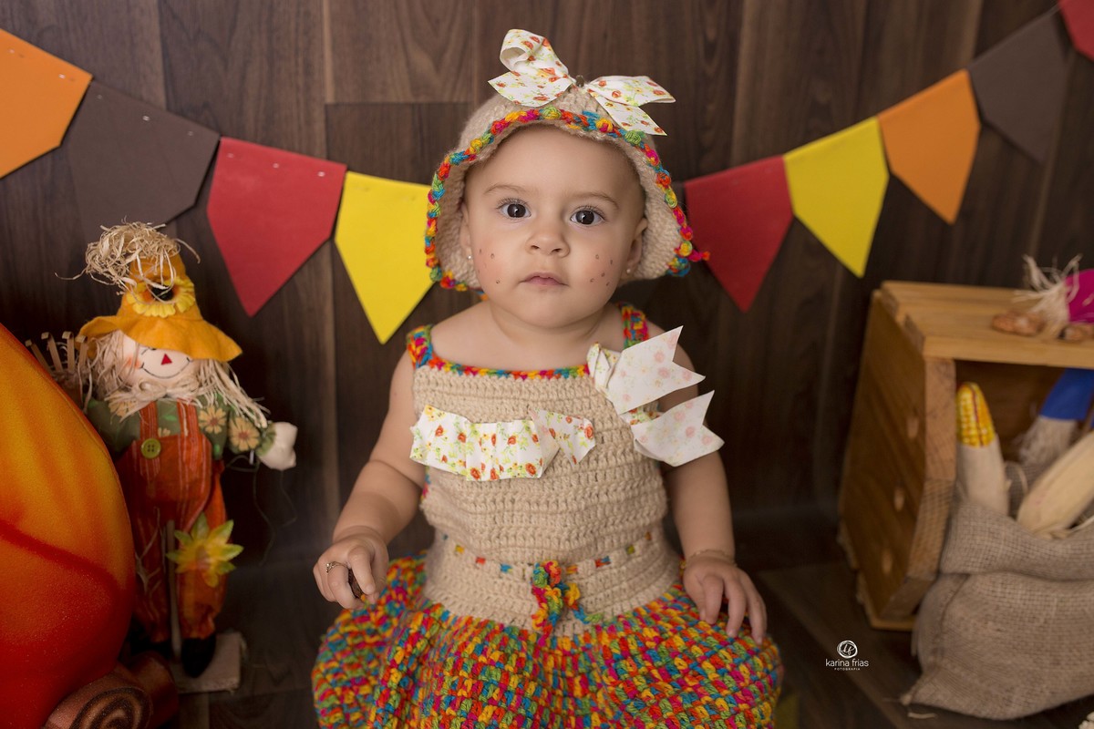 a bebe esta sentada no cenario junino