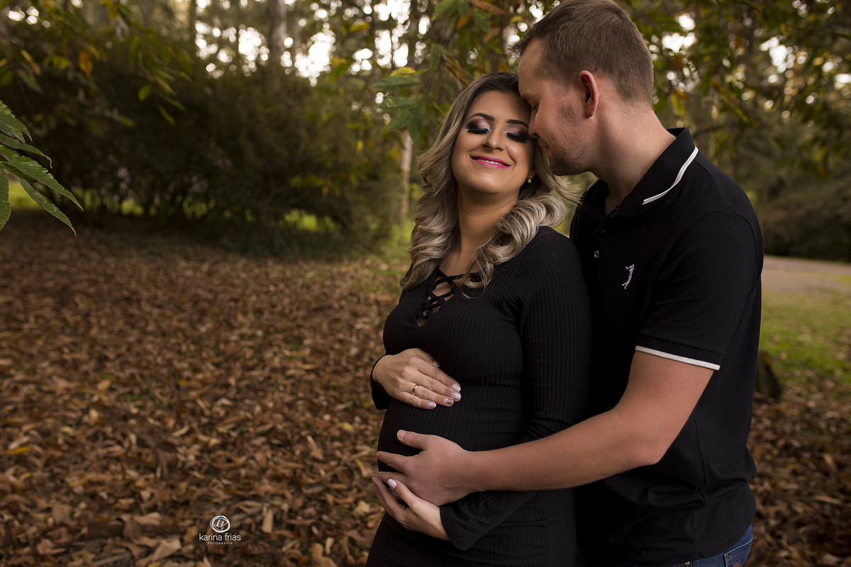 o pai abraça a a mãe durante as fotos da gravidez