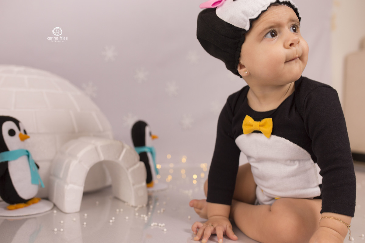 a bebe olha para os pais durante ensaio infantil