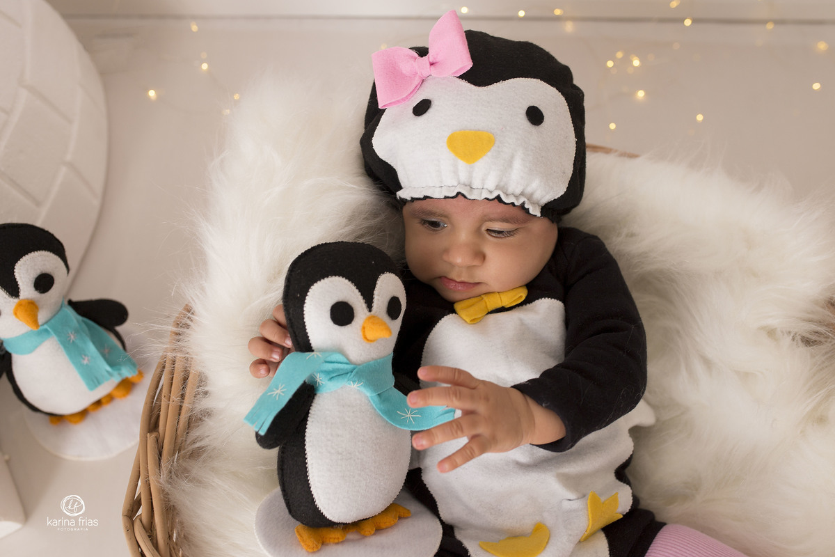 a menina segura o pinguim durante as fotos do acompanhamento mensal
