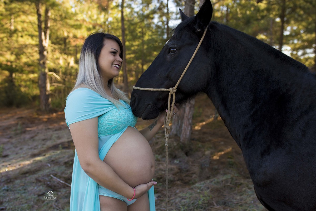 a gestante abraça o cavalo no seu ensaio externo