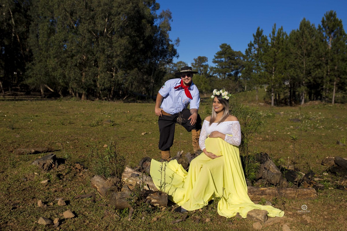 no ensaio de gestante os pais estao sentados ao sol