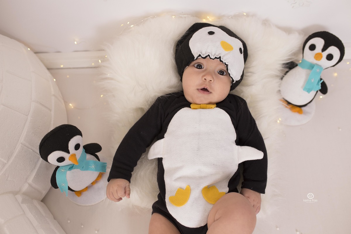 o bebe sorri para a camera na sessão de fotos mensais