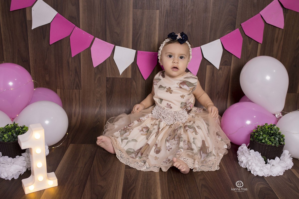 a bebe esta sentada no cenario rosa