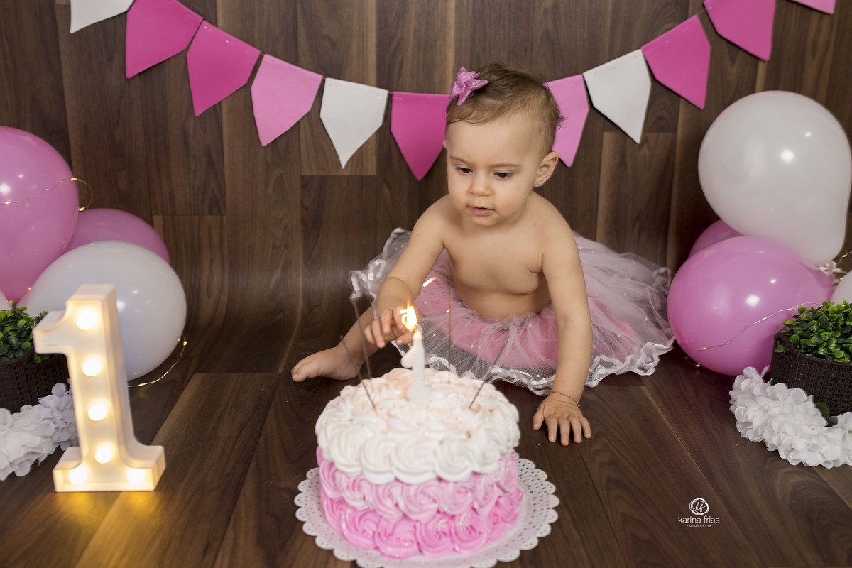 a bebe mexe na vela acesa do bolo de aniversario