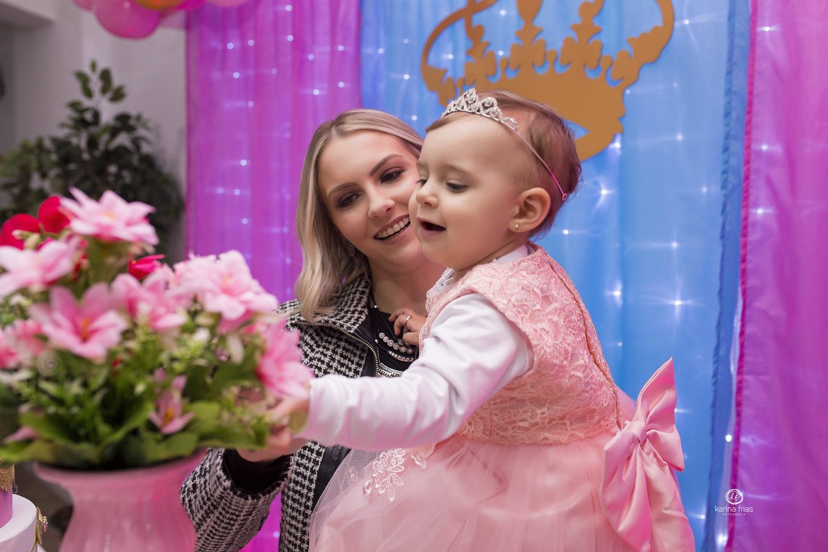 a menina sorri para as flores no dia do seu aniversario