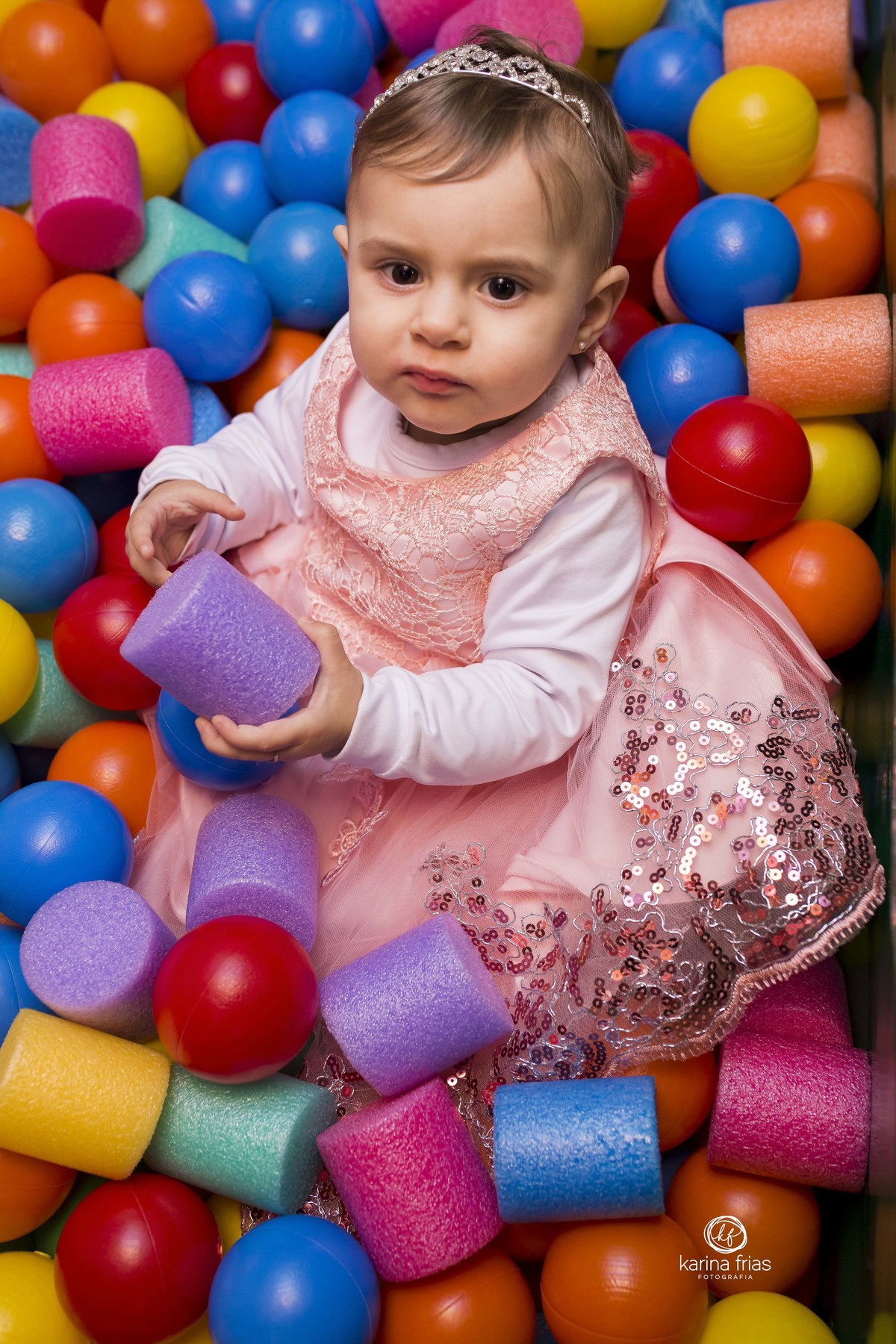 a menina brinca na piscina de bolinhas no aniversario de um ano