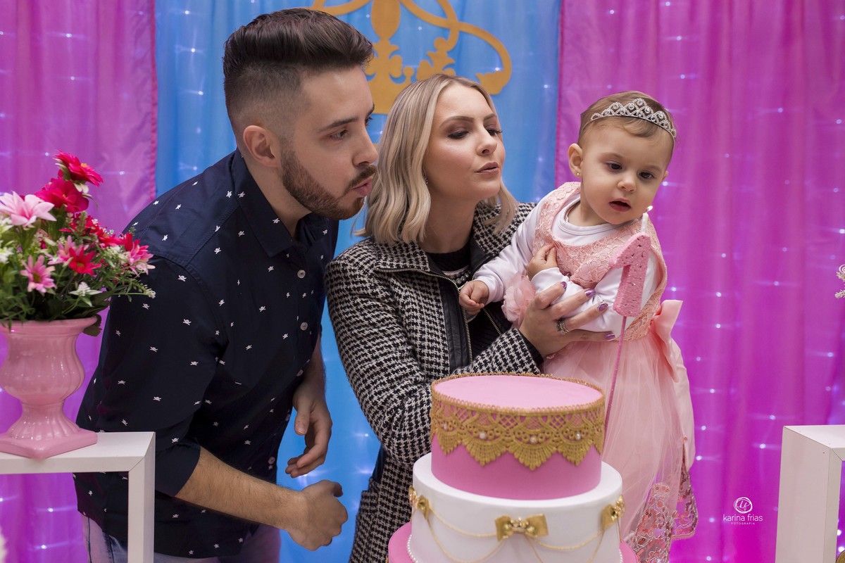 a familia assopra a vela para as fotos do aniversario