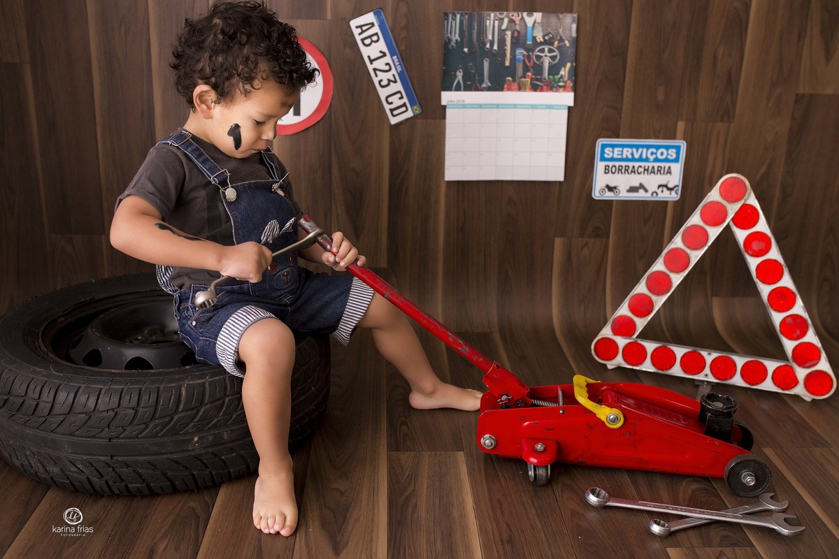 o menino brinca no cenario de borracharia