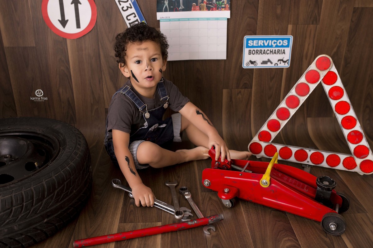 no ensaio de tres anos, a mae optou pelo cenario de borracharia