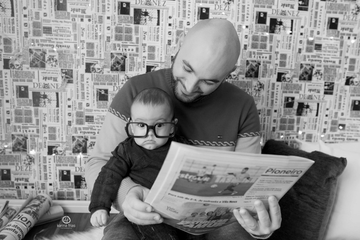 o bebe le o jornal com o pai