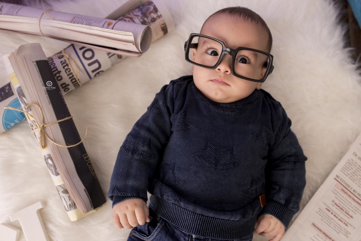 a criança esta usando oculos no cenario de jornal