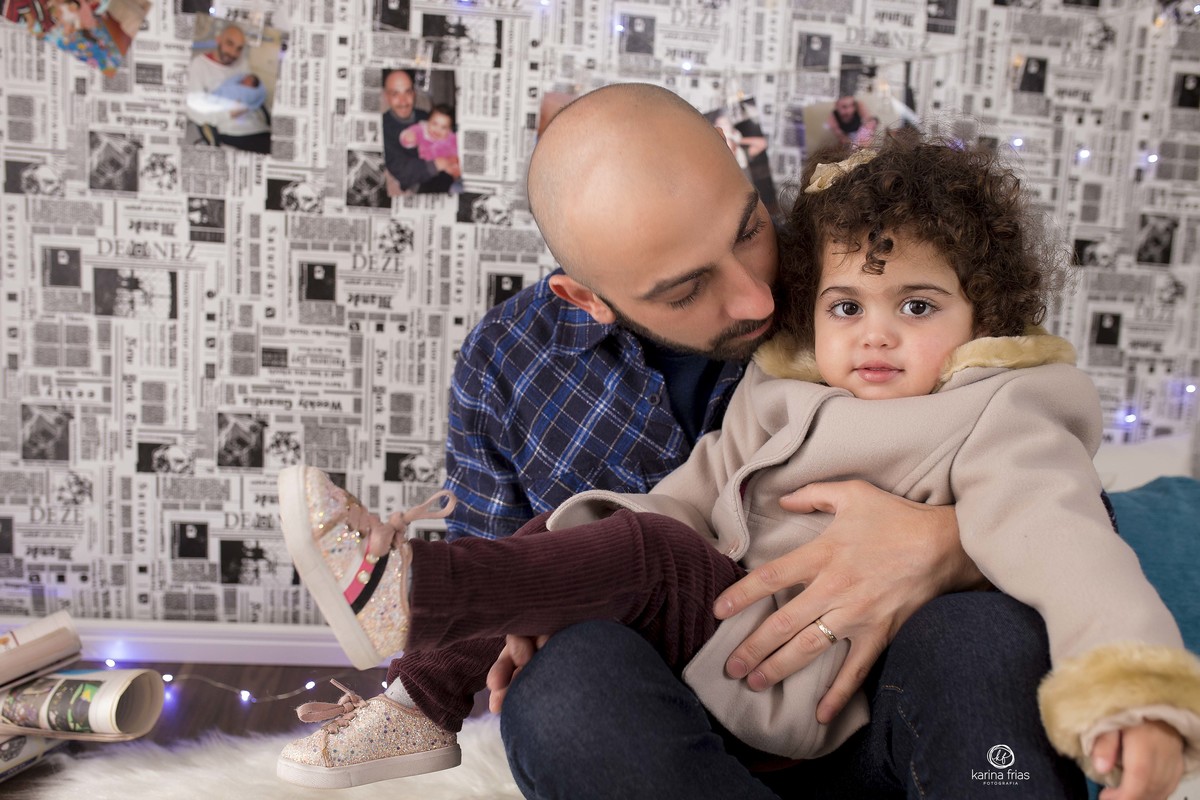 o pai segura a filha no colo durante sessão