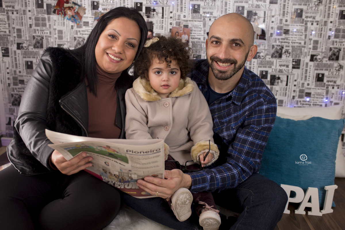 os pais posam com a filha na sessão de dia dos pais